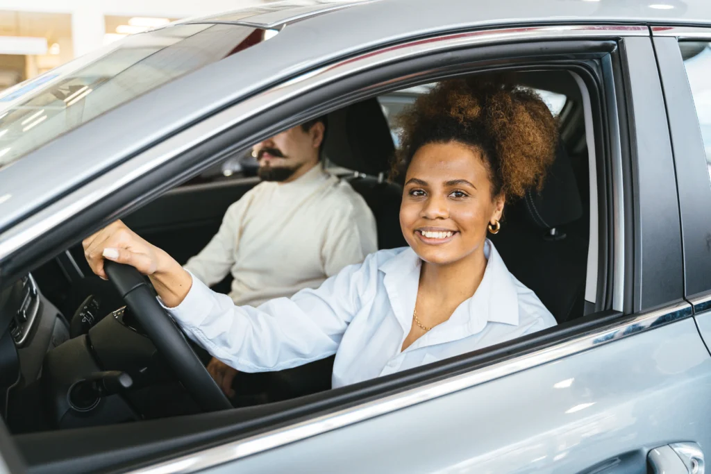 Beginner completing a successful first driving lesson with instructor