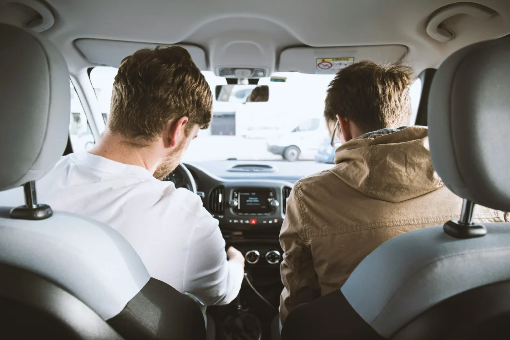 Professional instructor teaching defensive driving techniques to a new driver
