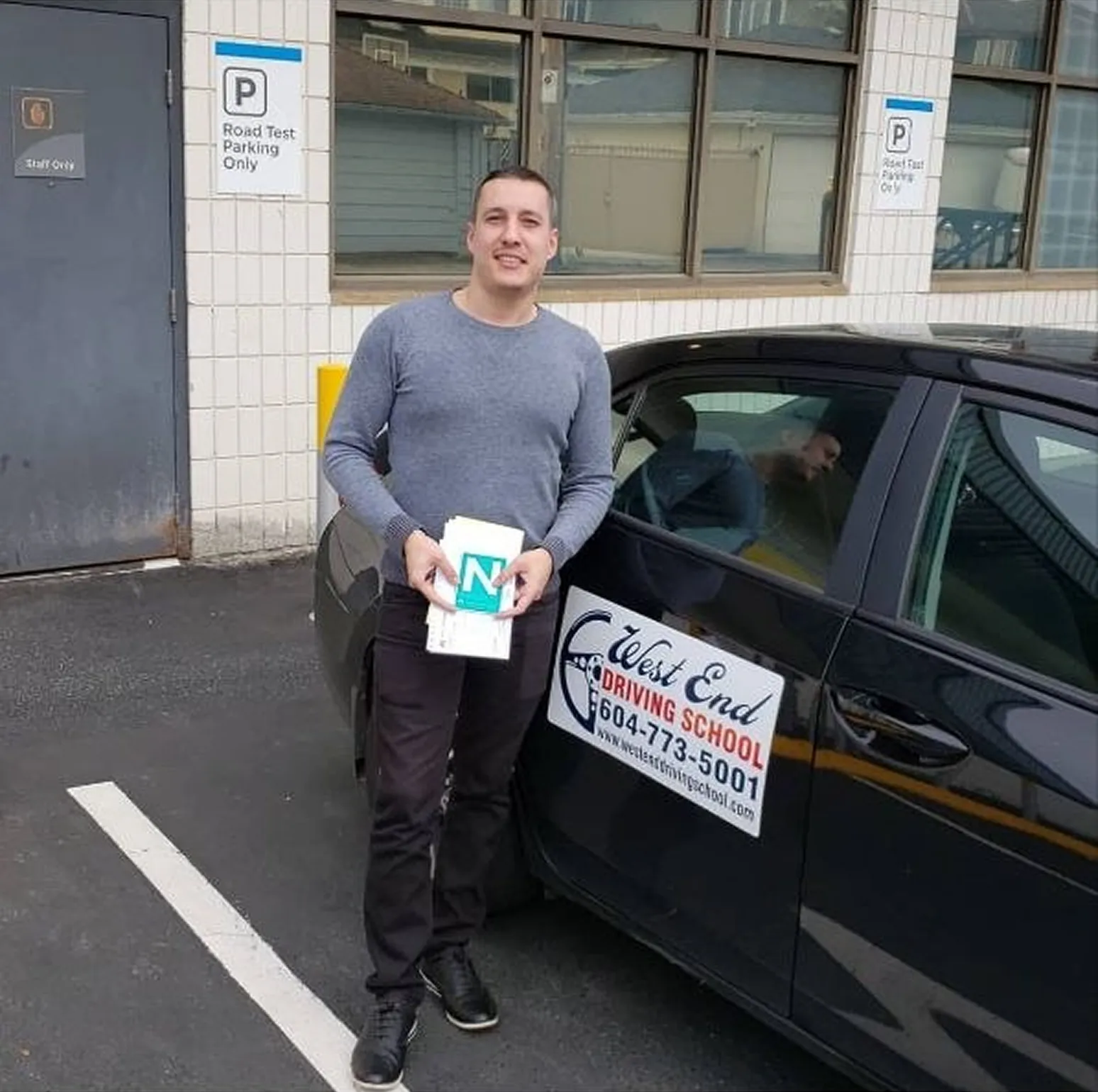 Student beside branded vehicle from driving school vancouver