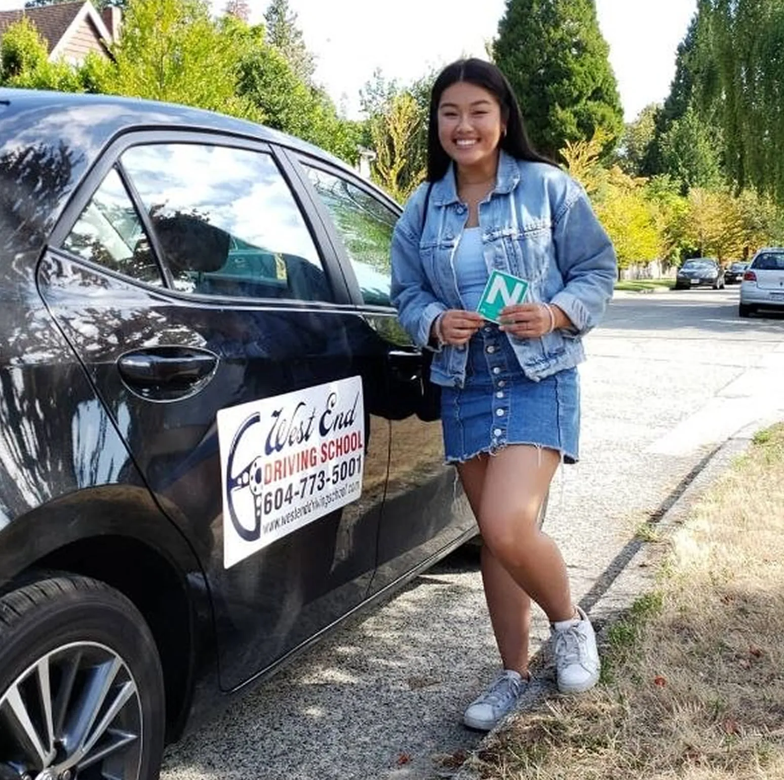 Student beside training car after driving school vancouver lesson